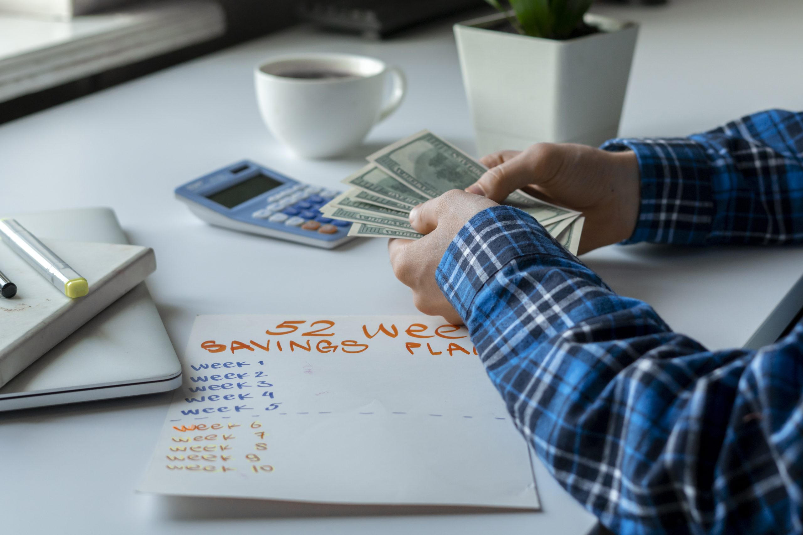 man counting money and planning weekly budget